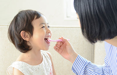 親が子どもの歯を磨いている